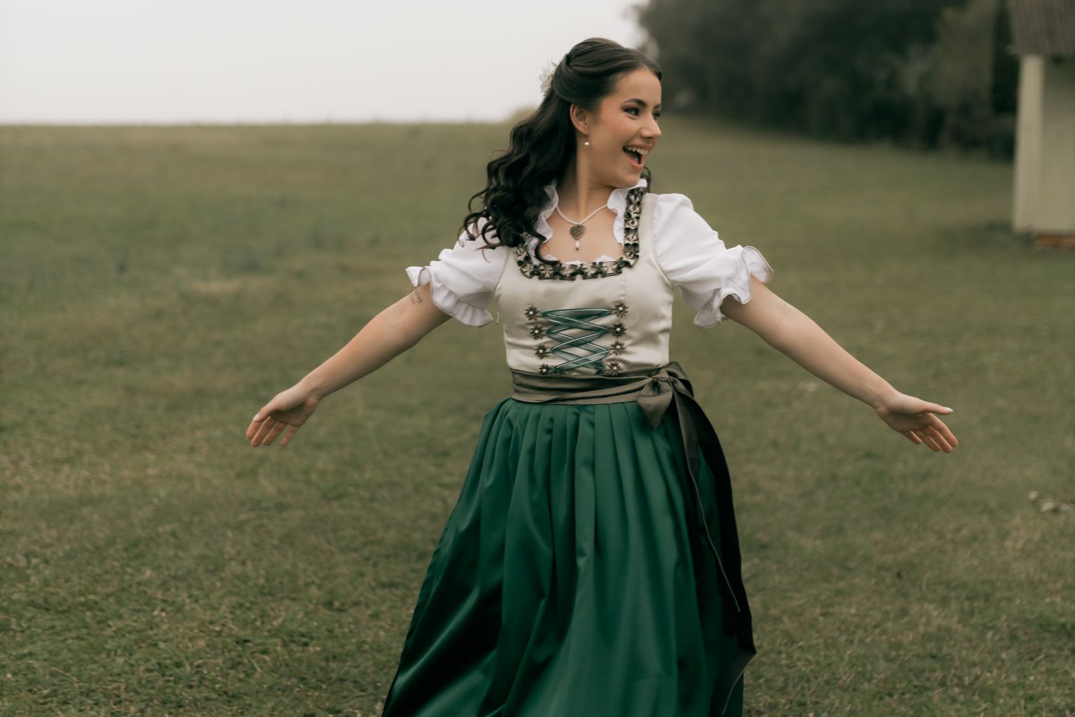 what to wear to Oktoberfest, woman in a dirndl dancing outdoors